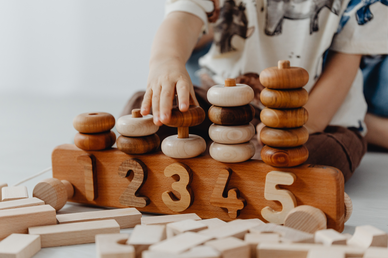 Child stacking numbered rings on a counting board