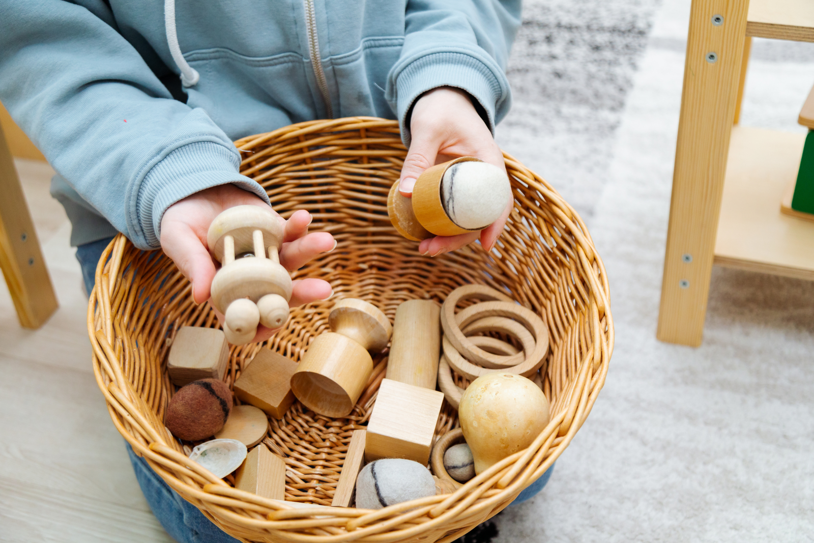 Adult hands sorting loose parts into a learning basket