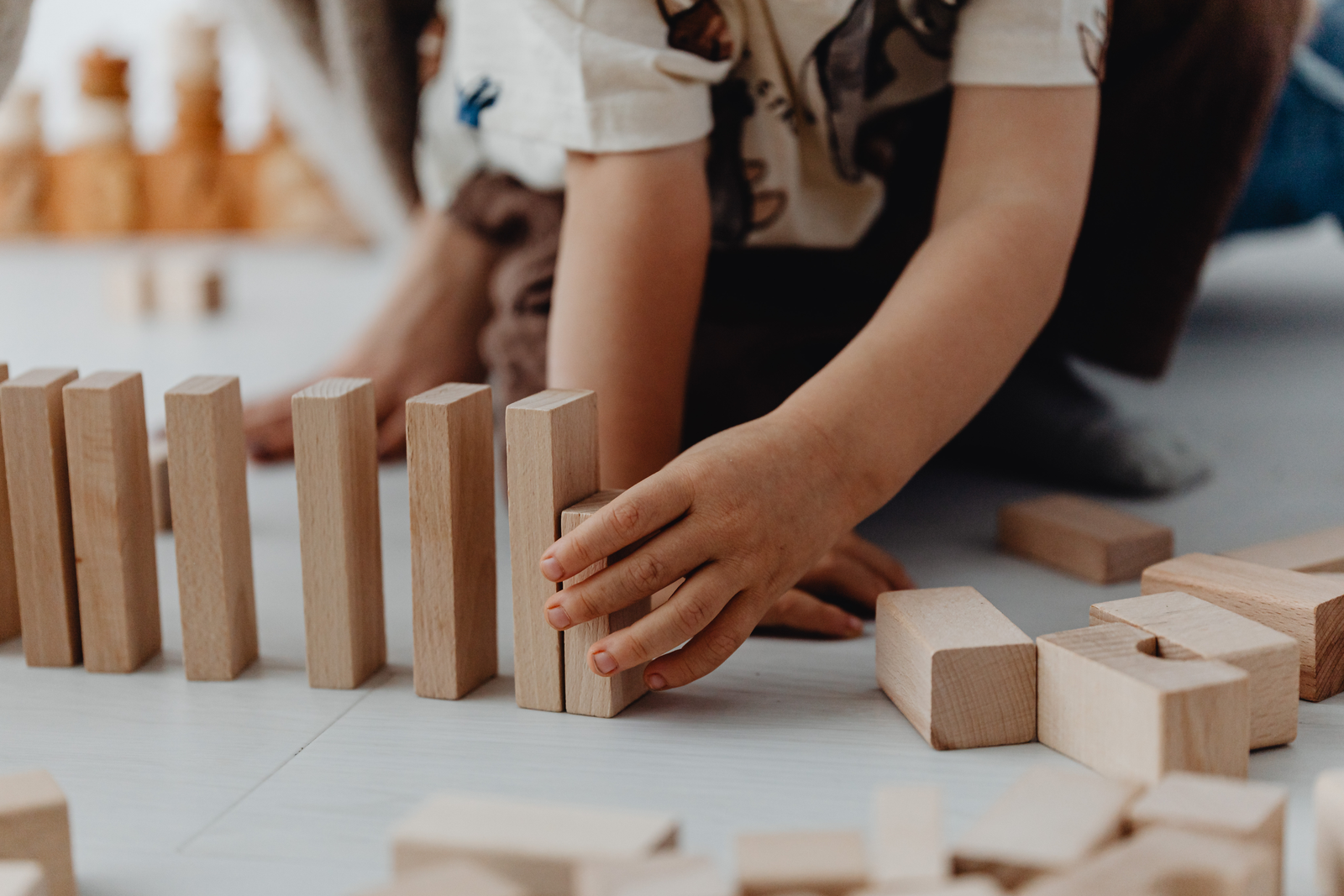 Child lining up wooden blocks in a purposeful pattern
